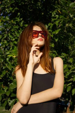 Siyah mayo giyen kadın güneş gözlüğü takıyor.