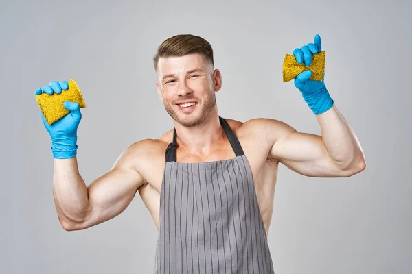 Een man in een schort met rubberen handschoenen afwassen — Stockfoto