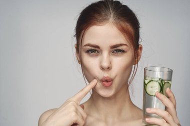 Salatalıklı kadın, yakın plan sağlık vitaminleri içer.