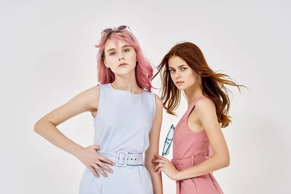 Duas amigas em roupas da moda estão de pé ao lado de estúdio de acessórios posando — Fotografia de Stock