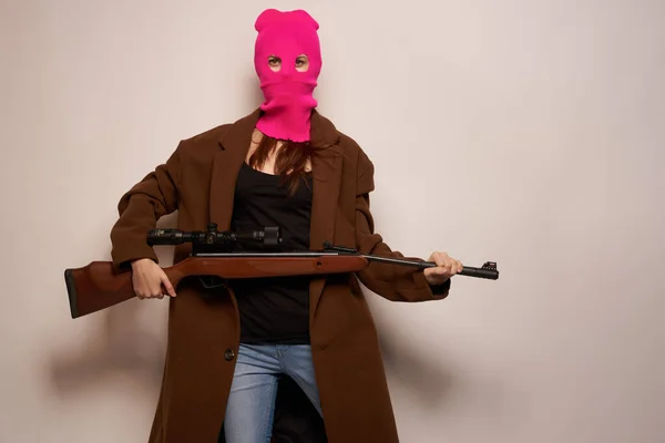 Femme en masque rose avec une arme à la main Lifestyle fond beige — Photo