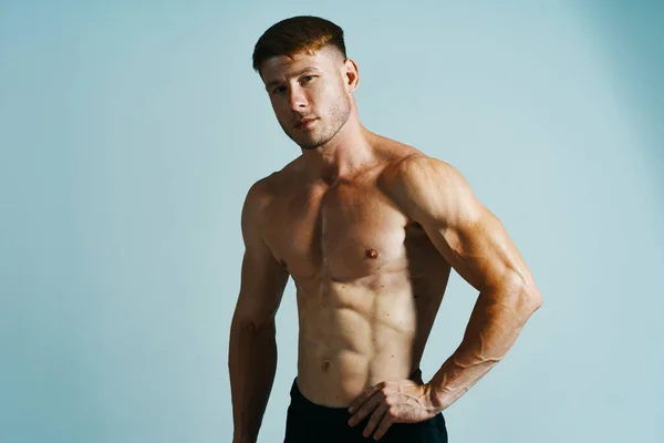 Bodybuilder met gespierd lichaam poseren pers blauwe achtergrond — Stockfoto