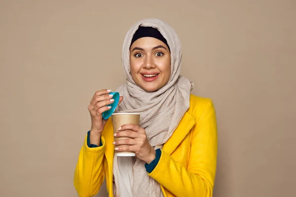 戴着太阳镜、头戴头巾、背景为米黄色的咖啡的女人 — 图库照片