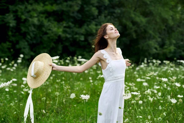 Donna in abito bianco cappello campo natura fiori — Foto Stock