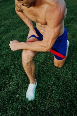 Atletik adam parkta koşma egzersizi yapıyor.