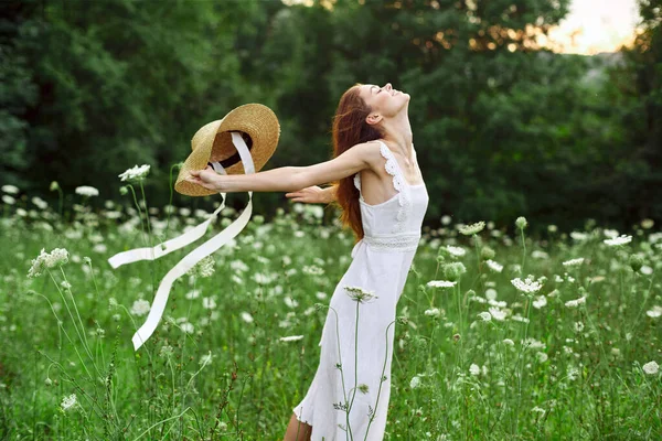 白いドレスの女性の帽子保持花自然ウォーク — ストック写真