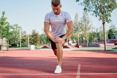 Adam dışarıda oyun sahasında egzersiz yapıyor.