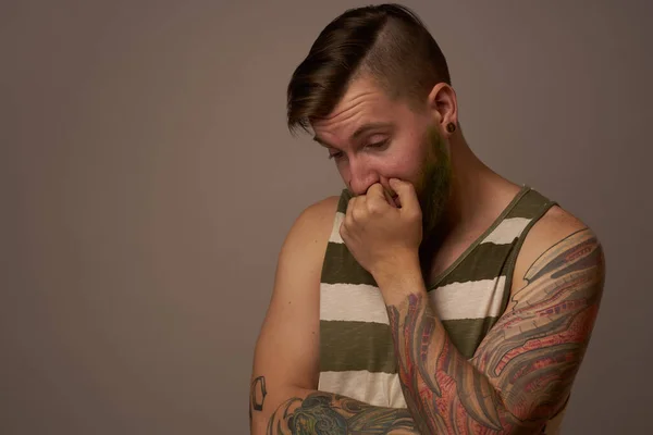 Uomo alla moda con tatuaggi sulle braccia elegante acconciatura studio di fiducia in se stessi — Foto Stock