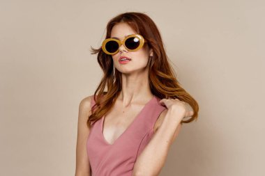 Pembe elbiseli güzel bir kadın poz veriyor.