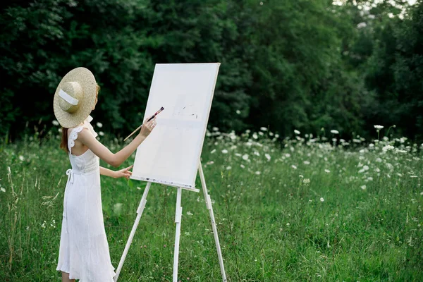 Woman in white dress paints a picture outdoors hobby creative — Stock Photo, Image