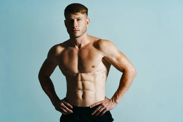 Bodybuilder met gespierd lichaam poseren pers blauwe achtergrond — Stockfoto
