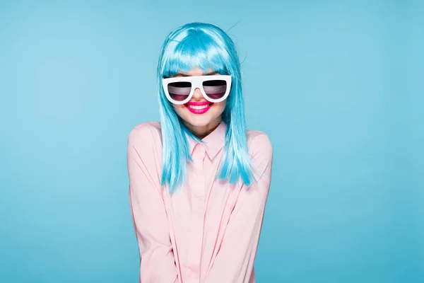 Atrakcyjna kobieta w fioletowe peruki okulary model niebieski tło — Zdjęcie stockowe