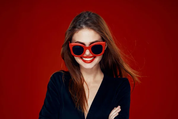 可愛い女性サングラスファッションポーズヘアスタイル赤の背景 — ストック写真