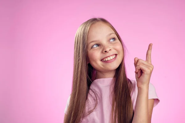 Ragazza carina con i capelli lunghi su sfondo rosa stile di vita infanzia — Foto Stock