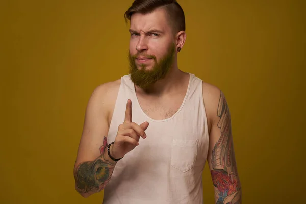 Homem barbudo alegre em uma camiseta branca com tatuagens de hooligan em seus braços — Fotografia de Stock