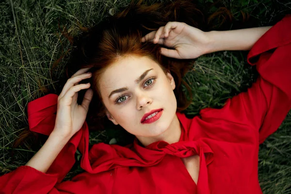 Женщина в красном платье лежит на траве адрес моды летом — стоковое фото