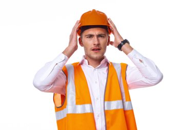 Turuncu üniformalı bir adam inşaat işinde.