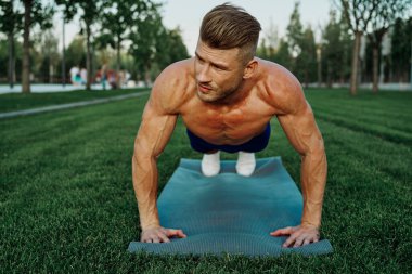 Spor kaslı adam parkta spor yapıyor.