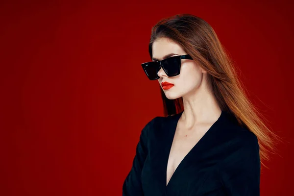 Alegre mujer de moda con gafas de sol labios rojos posando fondo rojo — Foto de Stock