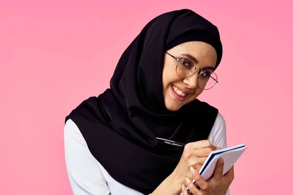 穆斯林妇女与计算器和金融货币粉红背景 — 图库照片