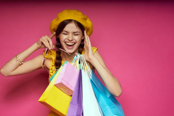 Vacker kvinna bär solglasögon poserar shopping mode rosa bakgrund — Stockfoto