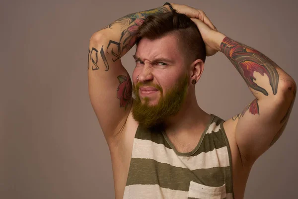 Homem bonito com tatuagens em seus braços emoções de penteado na moda — Fotografia de Stock