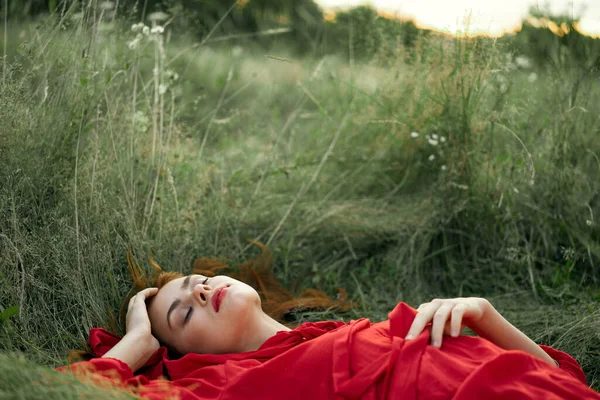 Frau in rotem Kleid liegt im Gras Frischluft Natur Romantik — Stockfoto