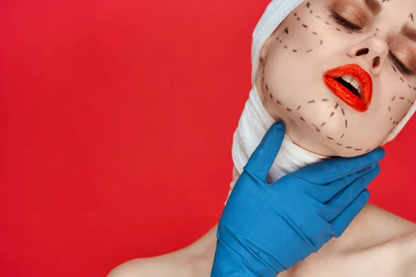 Eine Person mit blauen Handschuhen Spritze in den Händen Kontur auf dem Gesicht heben roten Hintergrund — Stockfoto