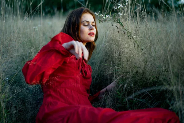 Woman in red dress lies on the grass nature freedom rest — Stock Photo, Image