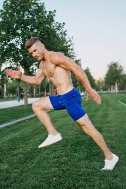 Parkta vücut egzersizi yapan atletik bir adam.