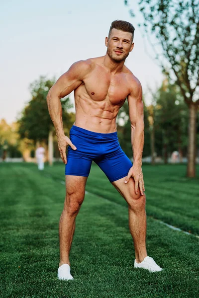 Atlético hombre con bombeado cuerpo muscular en el parque ejercicio ejercicio motivación — Foto de Stock