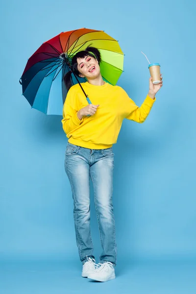 Mujer alegre con paraguas de color arco iris posando estilo de calle — Foto de Stock