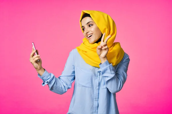 一个快乐的女人，头戴黄色头巾，手里拿着电话，通信技术 — 图库照片