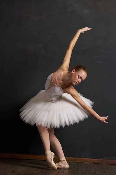 Donna ballerina in un bianco tutu danza posa prestazioni scuro sfondo — Foto Stock