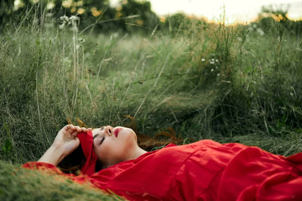 穿着红色衣服的女人躺在草地上新鲜空气自然浪漫 — 图库照片