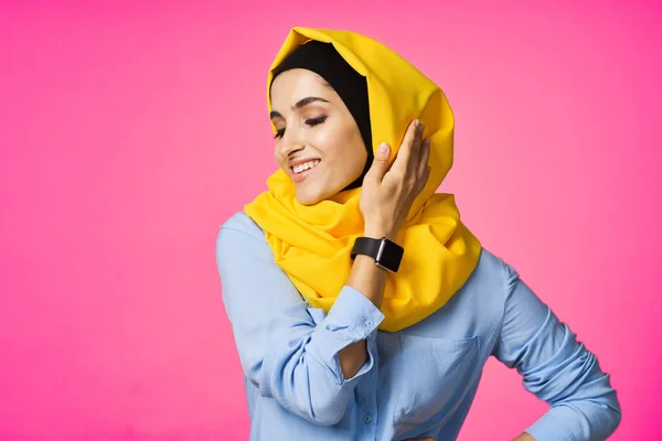 穿着黄色头巾的快乐女人电子手表技术用户粉色背景 — 图库照片