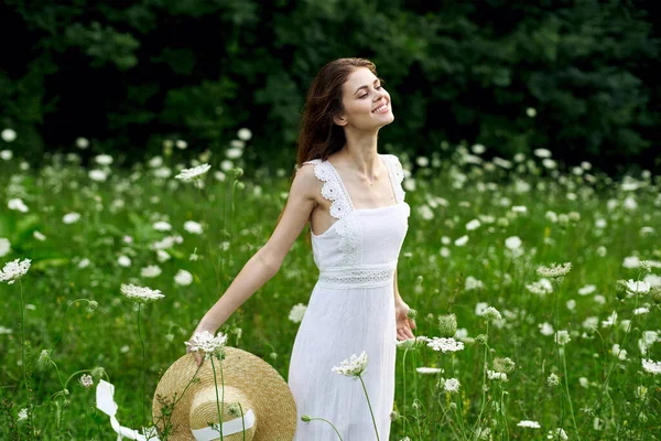 Donna in abito bianco cappello campo natura fiori — Foto Stock