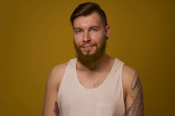 Hombre barbudo alegre en una camiseta blanca con tatuajes hooligan en sus brazos —  Fotos de Stock