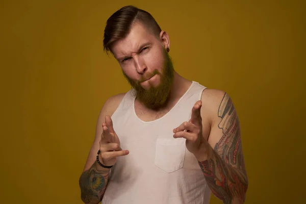 Hombre barbudo alegre en una camiseta blanca con tatuajes hooligan en sus brazos — Foto de Stock