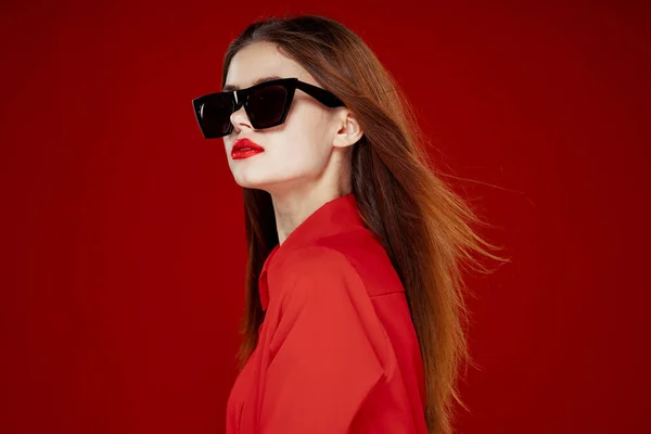 Hermosa mujer usando gafas de sol camisa roja maquillaje aislado fondo — Foto de Stock