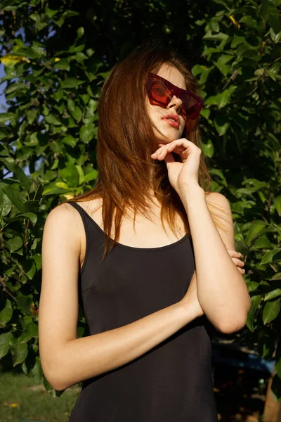 Güneş gözlüğü takan güzel kadın yaz pozu veriyor.