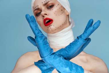 Elinde mavi eldiven şırıngası olan bir insan stüdyo yaşam tarzında yüz gerdirme şekilleri çiziyor.