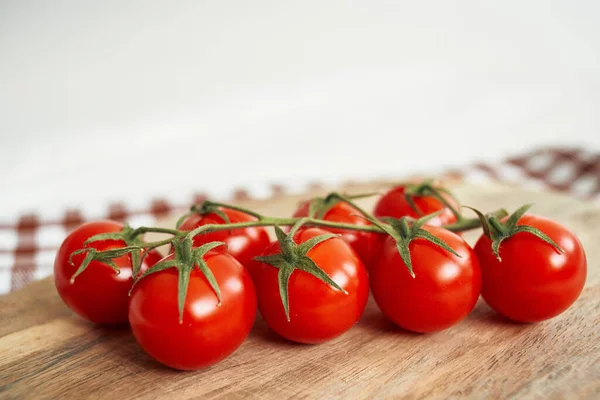 Comida Tomates cereza sobre tabla de cortar fondo de madera —  Fotos de Stock