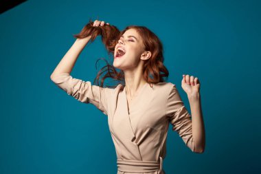 Çekici kadın, parlak makyaj saçı, mavi arka plan pozu.