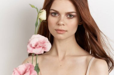 Çekici bir kadın elinde çiçeklerle cazibe dolu bir hayat sürüyor.