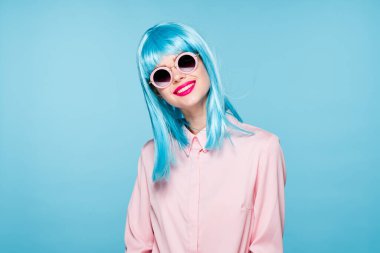 Mavi peruklu güzel kadın güneş gözlüğü takıyor.