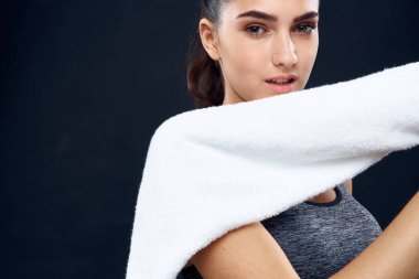 Neşeli sporcu kadın ellerinde beyaz havlu var.