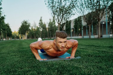 Spor kaslı adam parkta spor yapıyor.