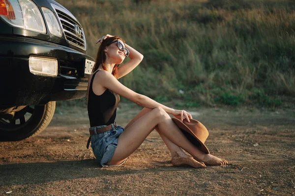 Женщина в солнцезащитных очках рядом с автомобилем — стоковое фото