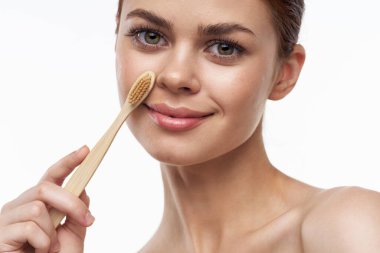 Çıplak omuzlu, neşeli bir kadın diş fırçası, diş fırçası, ağız bakımı.